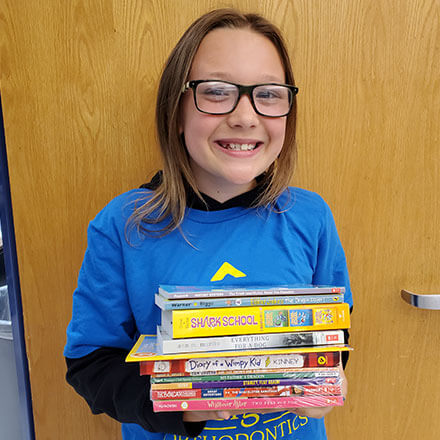 child smiling with books