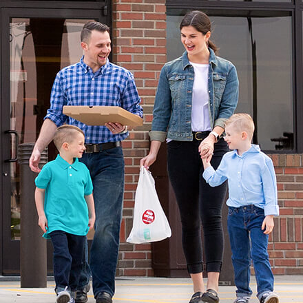 family leaving Casey's going to a pizza party with party supplies